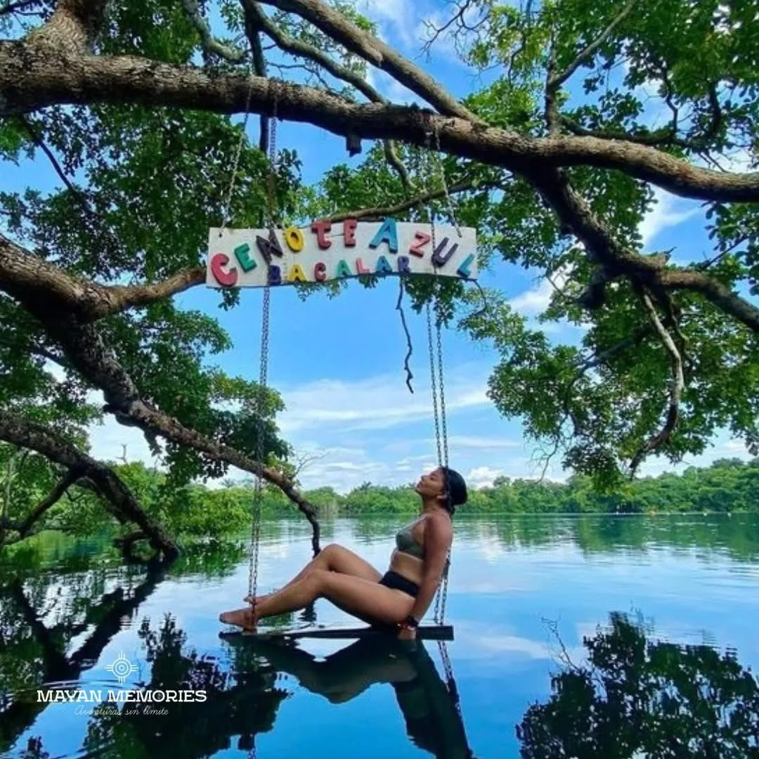 Woman on a rope swing under a tree by the lagoon