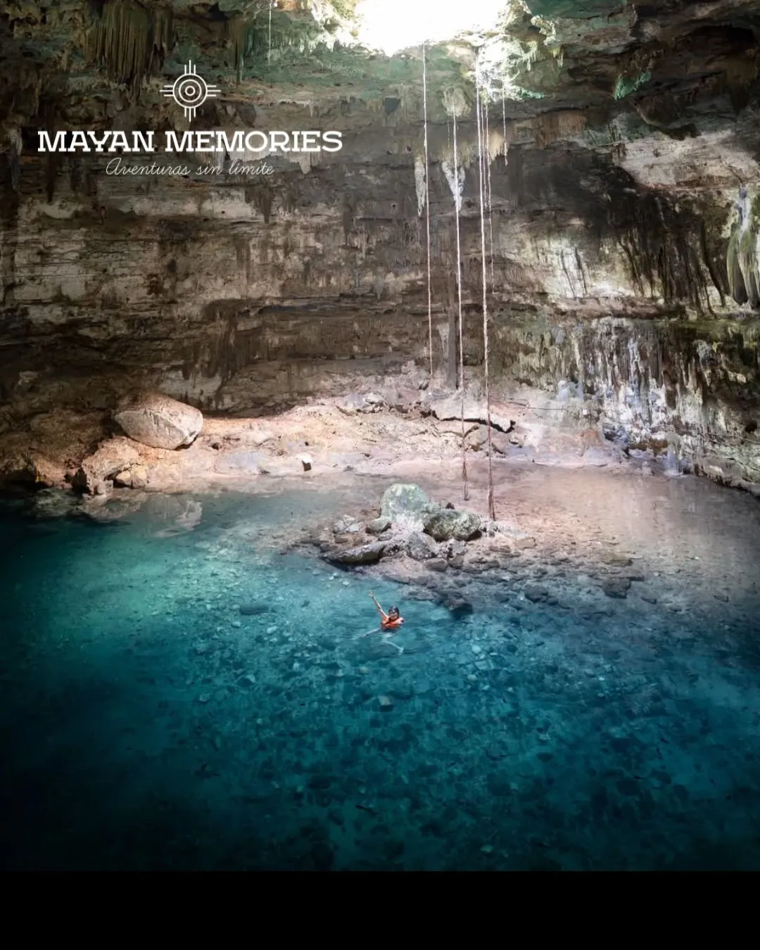 Swimmers in the blue water of a cave cenote