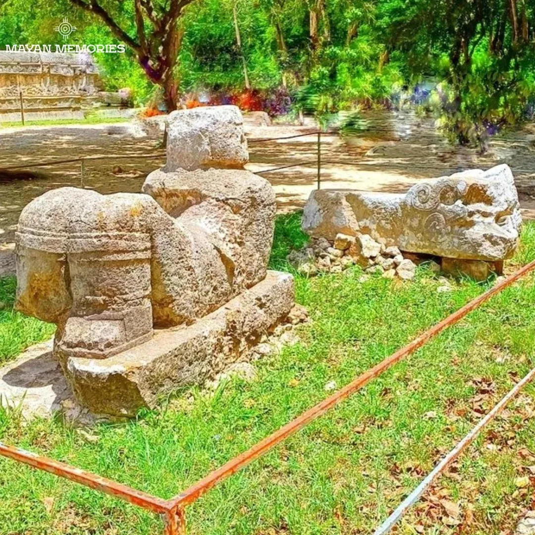 Carved stone serpent heads on the grass