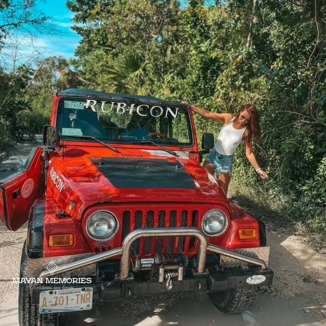 Woman beside a red jeep in the jungle