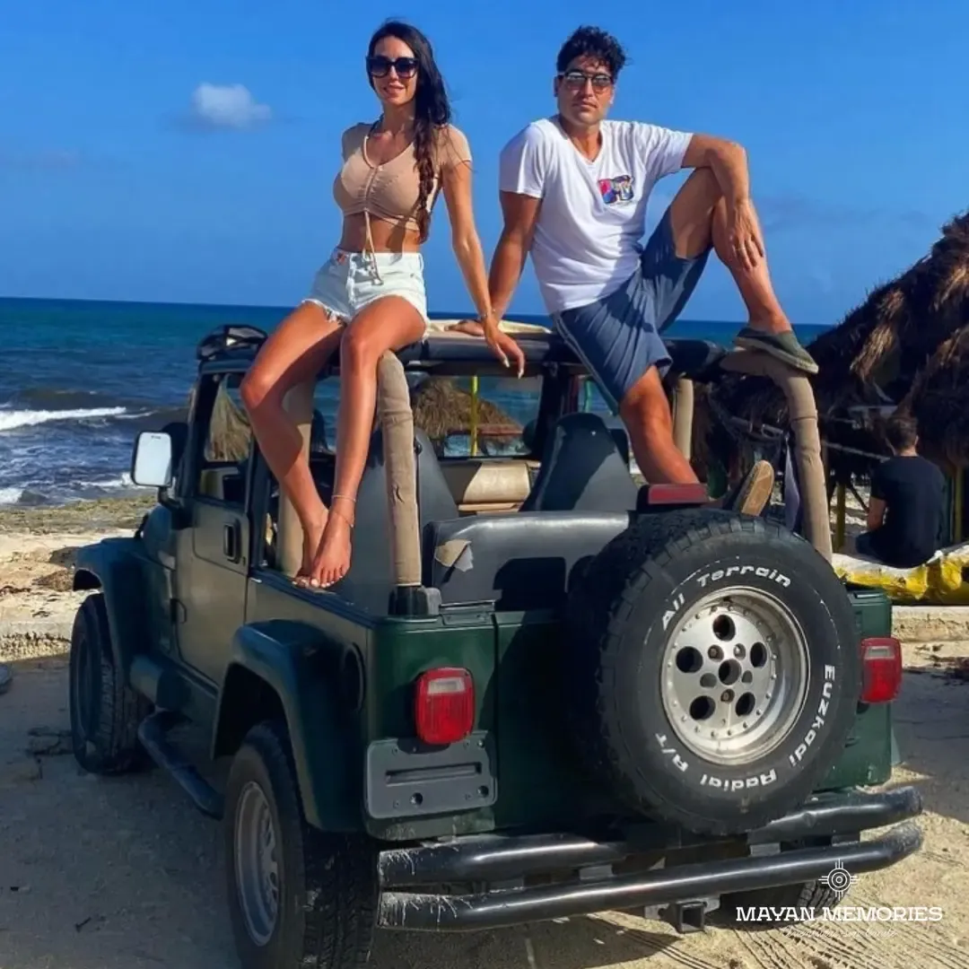 Two people sitting on top of a jeep with a spare tire