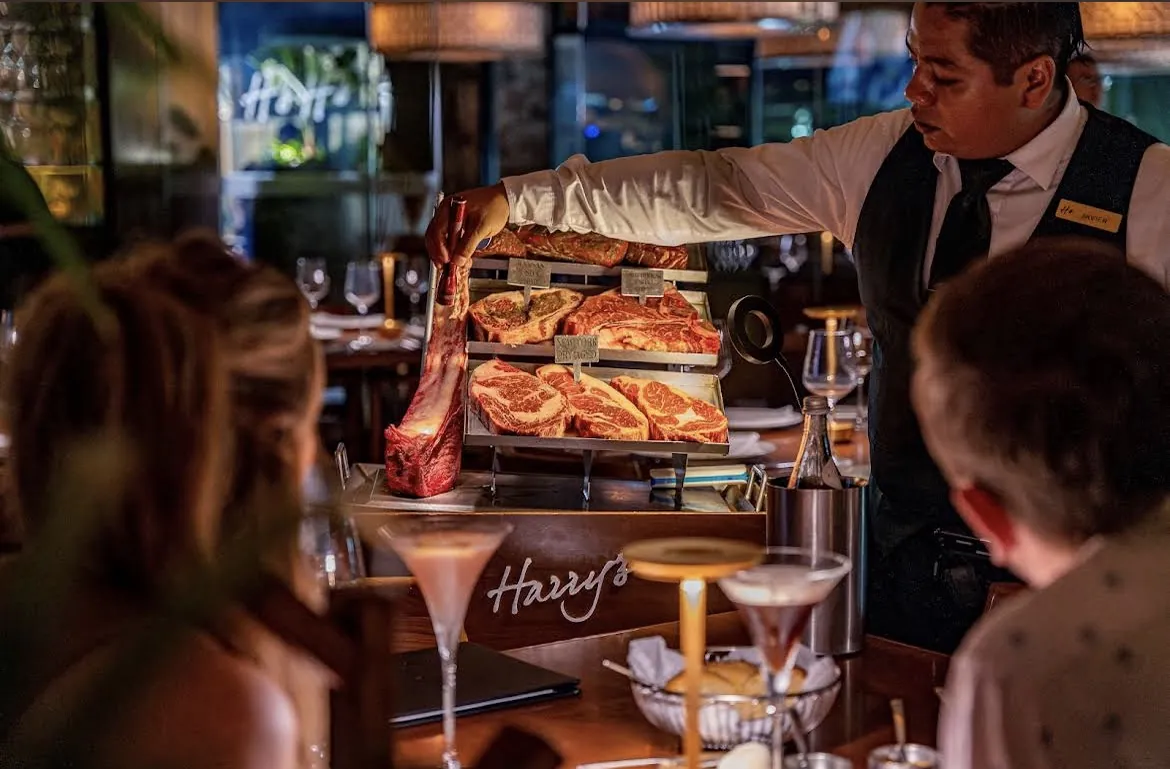 Waiter by the Harry's bar with lit bottles