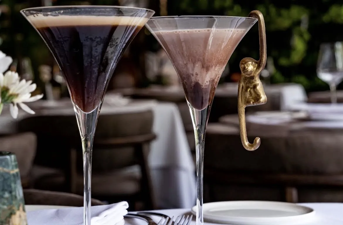 Two dark cocktails in martini glasses