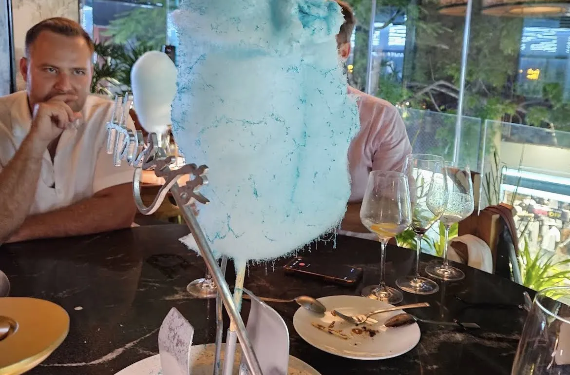 Diner in front of a blue cotton candy dessert