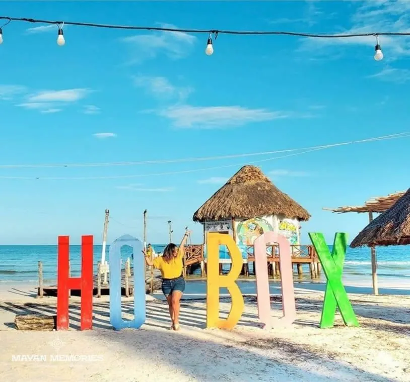 Colorful Holbox letters on the beach beside a palapa