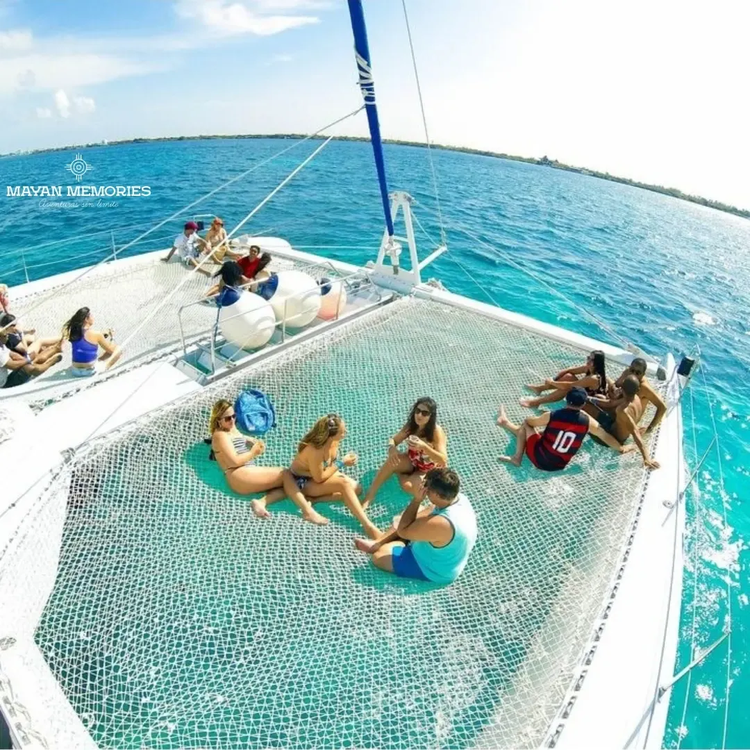 People relaxing on the catamaran net over turquoise water
