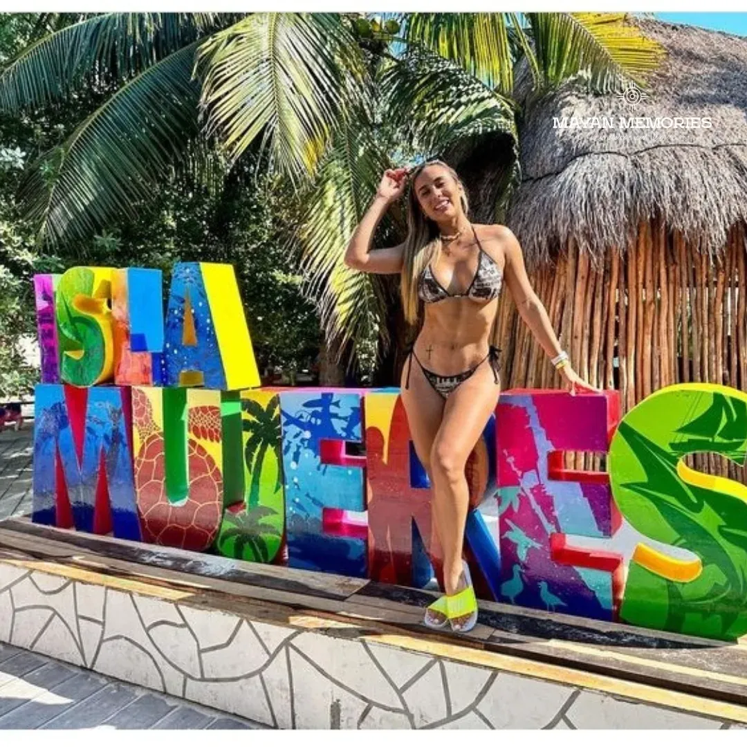 Woman in a bikini posing at the colorful Isla Mujeres letters