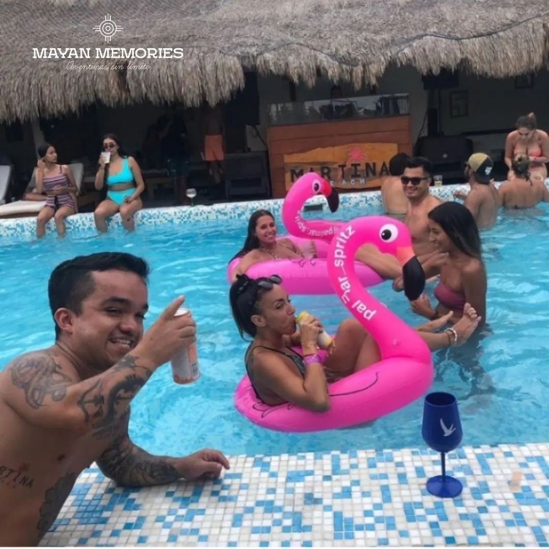 People in the pool with pink flamingo floats