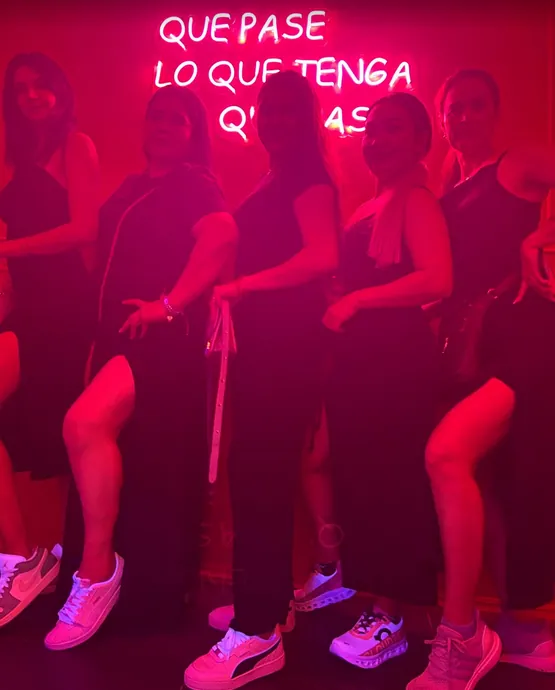 People dancing under red lights on the dance floor