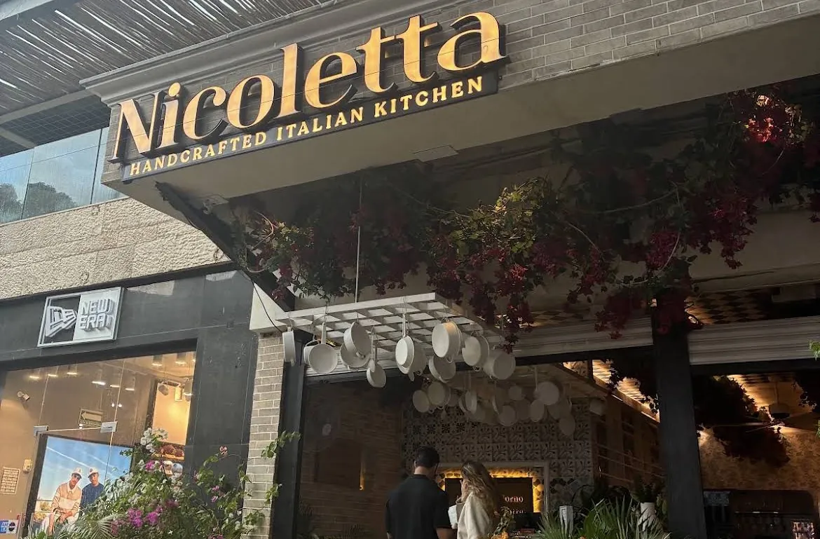 Nicoletta's facade with its sign and terrace tables