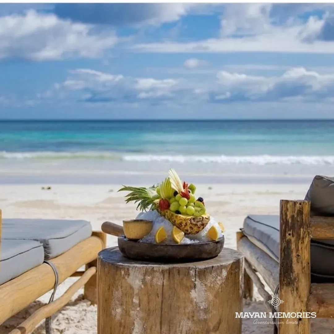 Plate of fruit on the table with the beach and sea behind