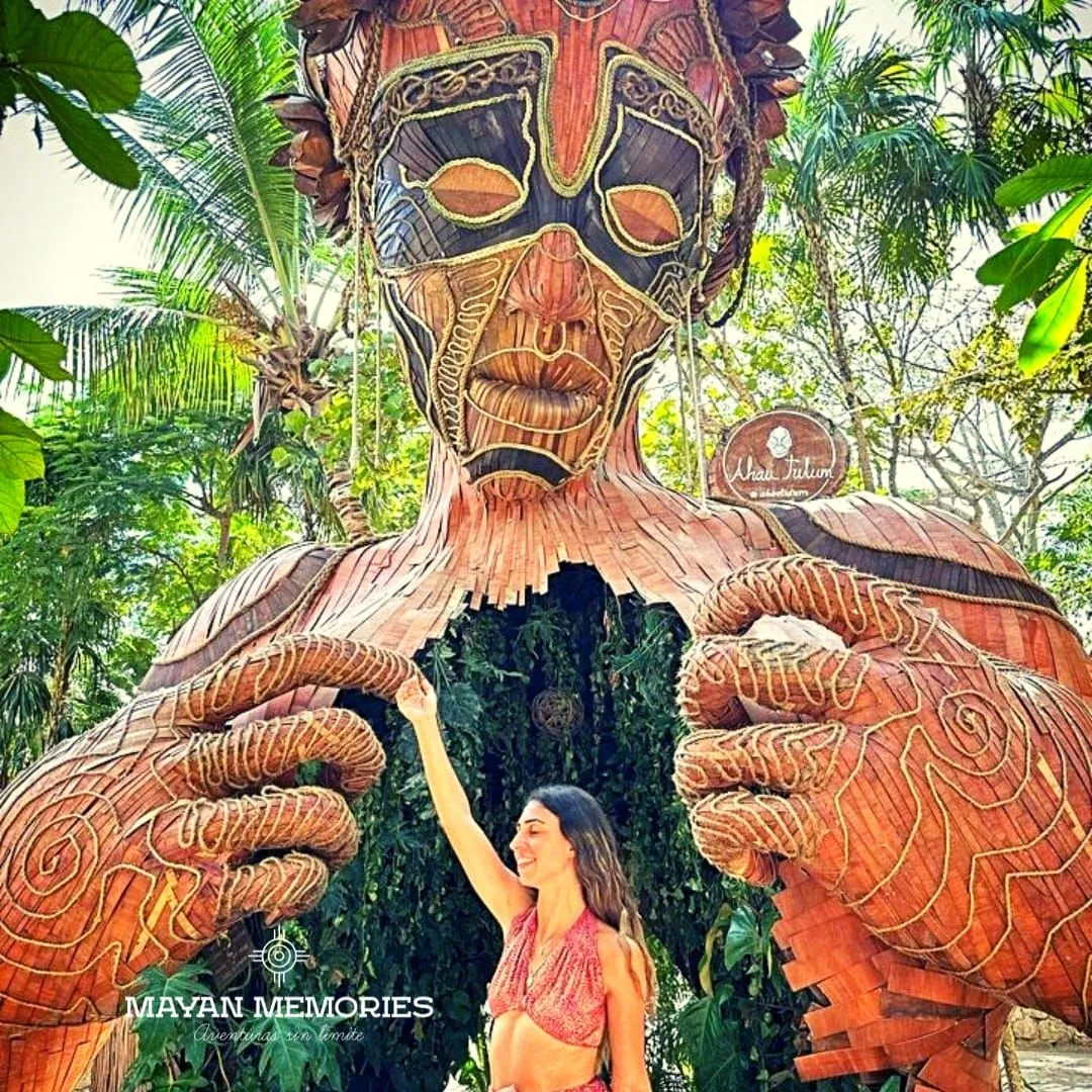 Visitor between the hands of the giant wooden Mother Nature sculpture