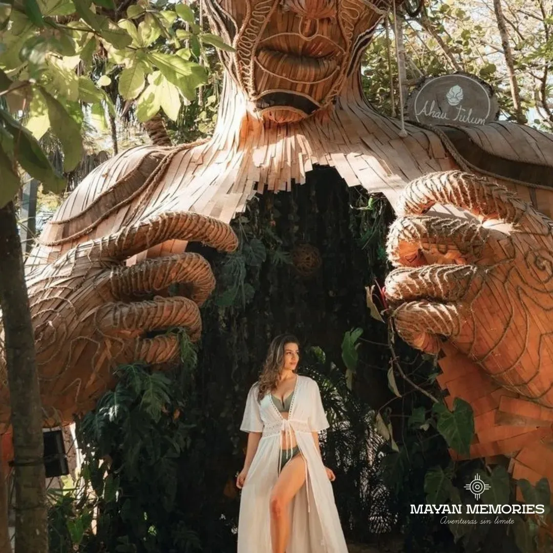 Woman in white between the giant hands of the wooden sculpture