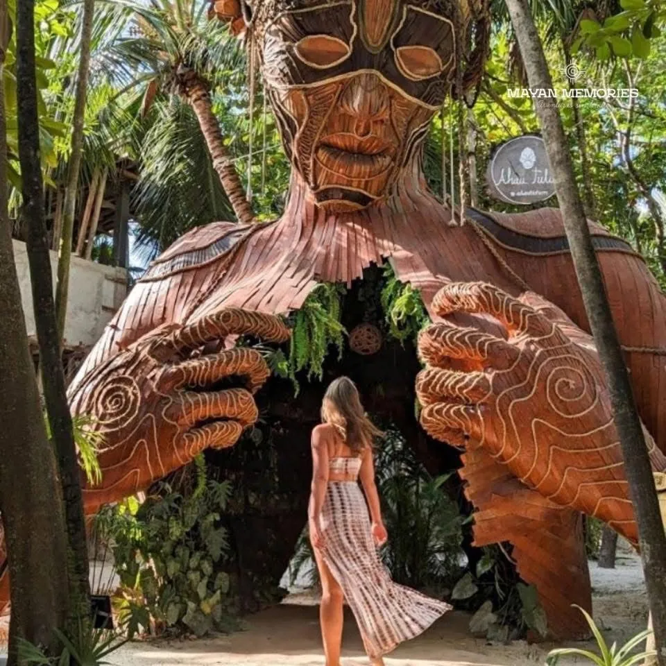 Visitor in front of the wooden Mother Nature sculpture