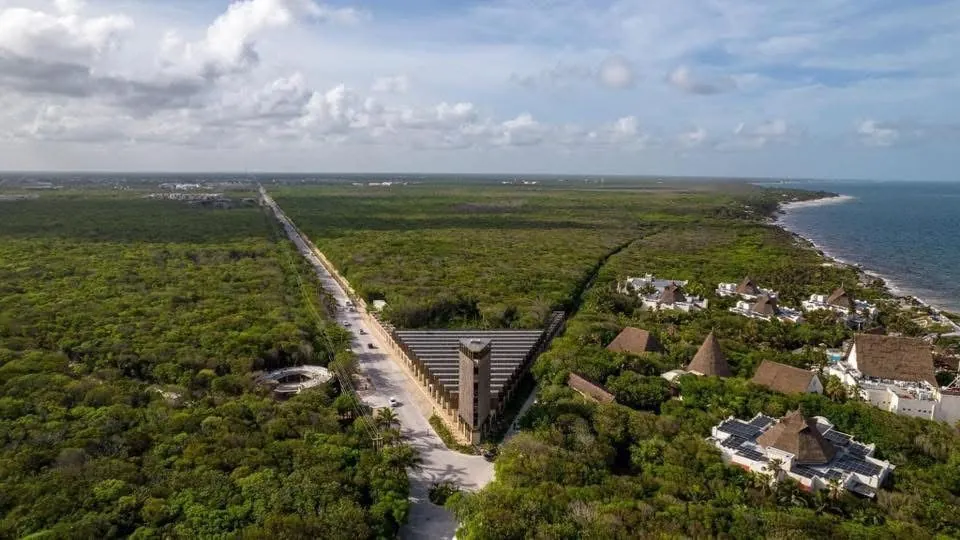Aerial view of the Tulum jungle with a road and a tower