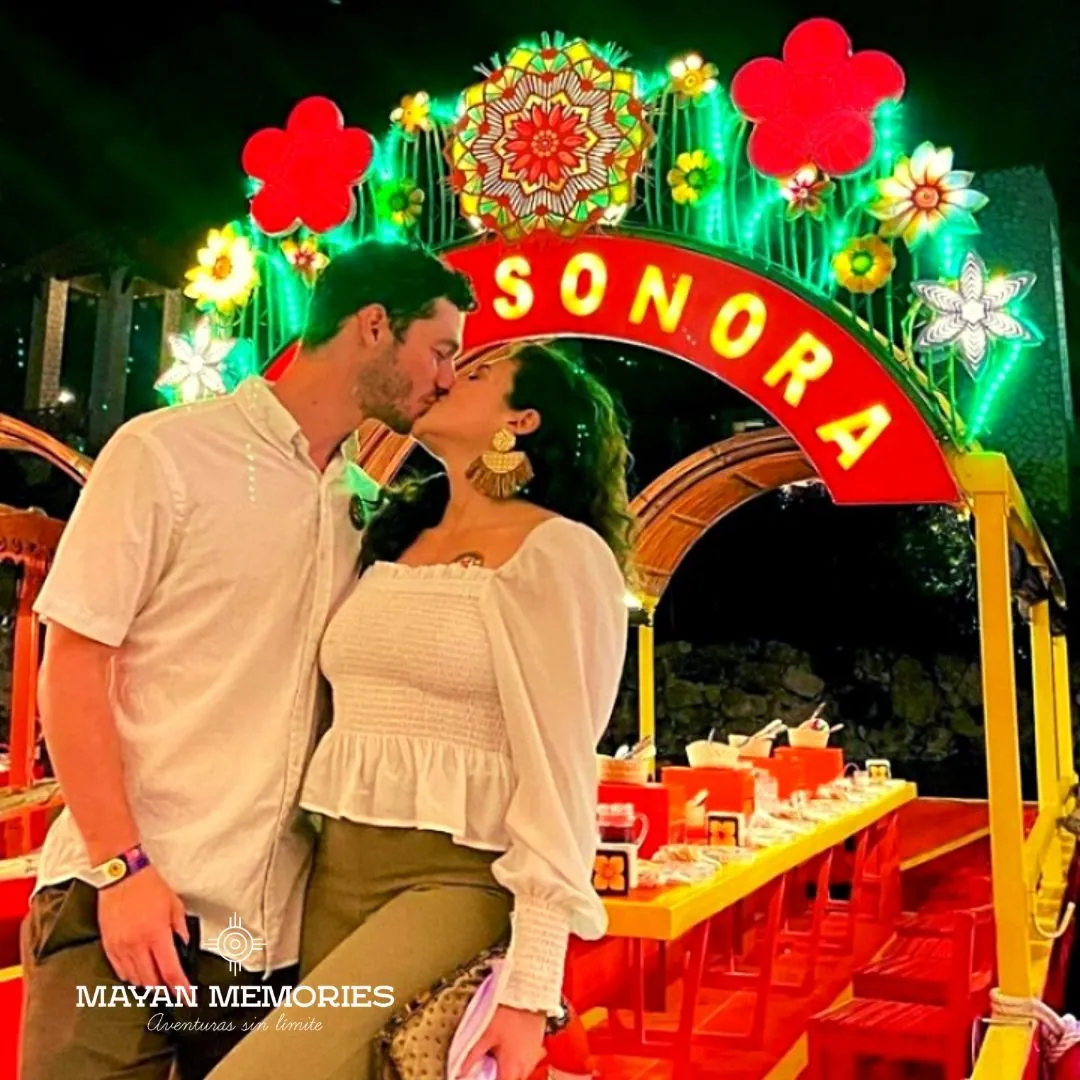 Couple kissing under the lit arch of a trajinera