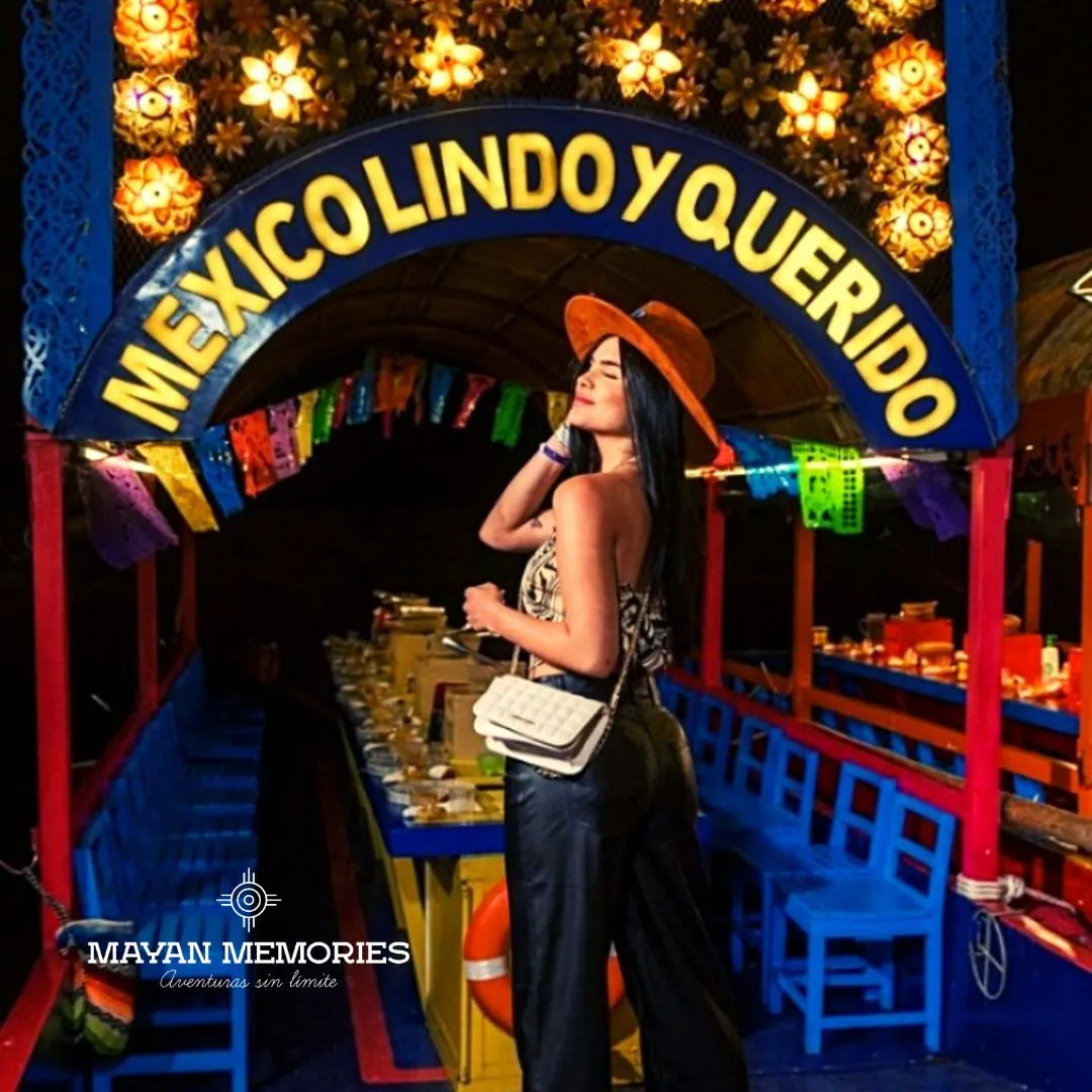 Woman in a hat aboard a decorated trajinera at night